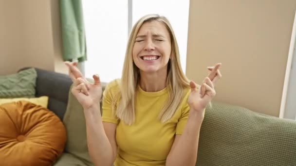 Evdeki Neşeli Sarışın Kadın Umut Dolu Bir Jestle Parmaklarını Çapraz — Stok video