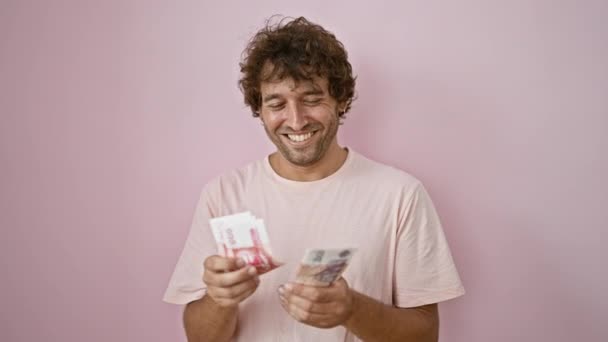 快乐的年轻人 背负着粉色背景的冰岛克朗钞票 流露出一种快乐和经济上的轻松自在 — 图库视频影像