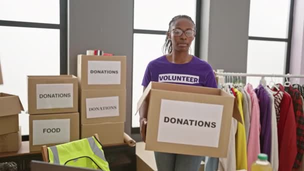 有重点的妇女志愿者在一个设有纸盒和衣服的慈善中心房间里组织室内捐赠 — 图库视频影像
