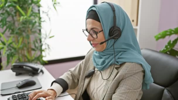 Eine Lächelnde Frau Hijab Mit Headset Und Computer Einem Büroumfeld — Stockvideo