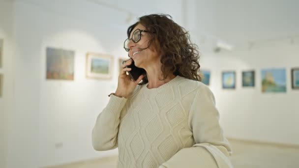 Усміхнена Жінка Середнього Віку Окулярах Розмовляє Телефону Художній Галереї — стокове відео