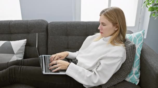 Uma Jovem Mulher Loira Estressada Usa Laptop Sofá Quarto Acolhedor — Vídeo de Stock