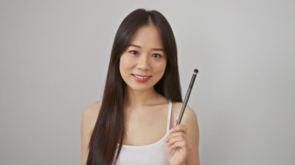 Sonriente Joven Asiática Mujer Sosteniendo Maquillaje Cepillo Contra Blanco Fondo — Vídeos de Stock