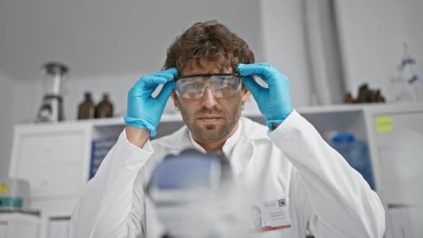Ein Fokussierter Wissenschaftler Mit Bart Und Schutzbrille Forscht Einem Laborumfeld — Stockvideo