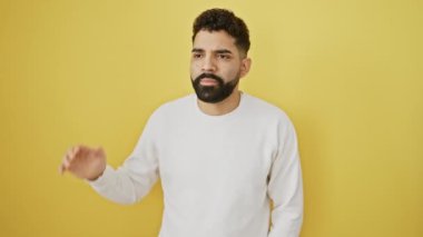 Öfkeli genç adam, yüksek sesle bağırıyor, sarı arka planda duran adalar. Çığlık attığında ağzı açılır, elleri bağırışını güçlendirir. Ham iletişimin somutlaşması.