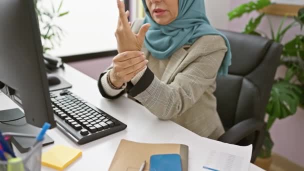 Dojrzała Muzułmanka Hidżabie Odczuwa Ból Nadgarstka Stanowisku Pracy Komputerem Rośliną — Wideo stockowe