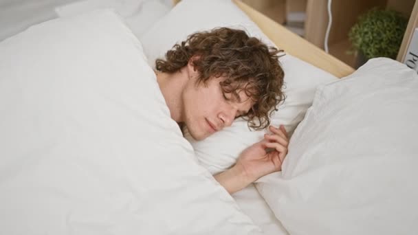 一个安静的年轻人睡在一个舒适明亮的卧室里 卧室里有白色的床上用品和木制的床头柜 — 图库视频影像