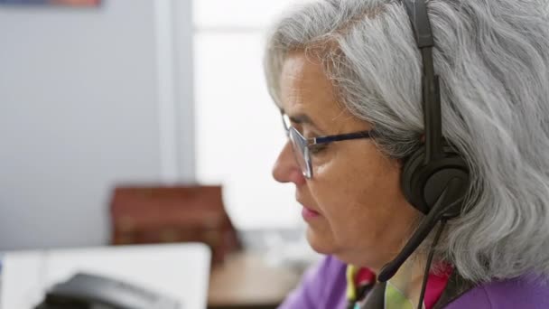 Mujer Madura Con Pelo Gris Auriculares Sonriendo Entorno Oficina Exudando — Vídeos de Stock