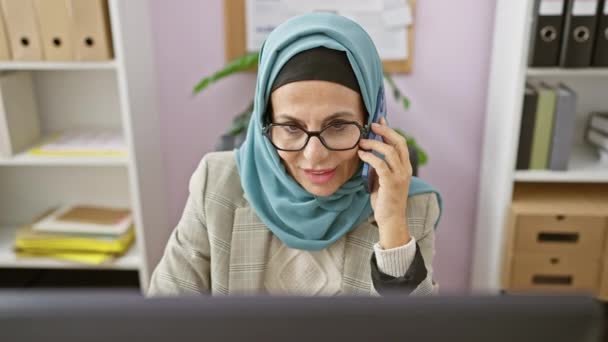 Egy Hivatásos Középkorú Hidzsábot Visel Modern Irodai Környezetben Beszél Telefonon — Stock videók