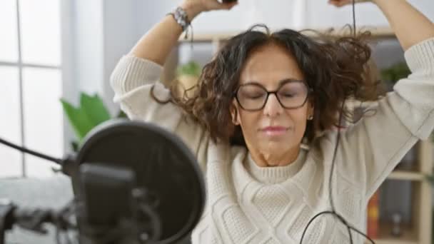 Mulher Hispânica Madura Desfrutando Música Com Fones Ouvido Ambiente Acolhedor — Vídeo de Stock