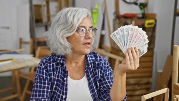 Женщина Средних Лет Седыми Волосами Держащая Злотые Банкноты Закрывающие Рот — стоковое видео
