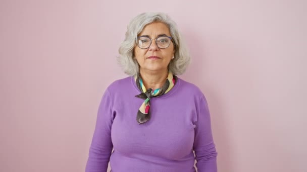 Šedovlasá Žena Středního Věku Brýlemi Stojící Nad Růžovým Izolovaným Pozadím — Stock video