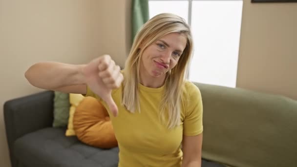 怒っている不幸なブロンドの女性は Tシャツを着ている間 家庭でのジェスチャー 拒絶的な表情 否定的な雰囲気を示しています — ストック動画
