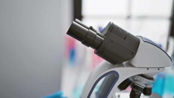 一个专注的女人在明亮的实验室环境中使用显微镜传播技术和科学研究 — 图库视频影像