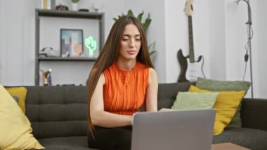 Modern bir oturma odasında meditasyon yapan odaklı bir kadın gitar ve arka planda dekoratif raflarla..