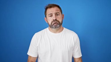 Mavi arkaplana karşı gri saçlı, yalvaran olgun bir adamın portresi, samimi bir ricada bulunuyor..