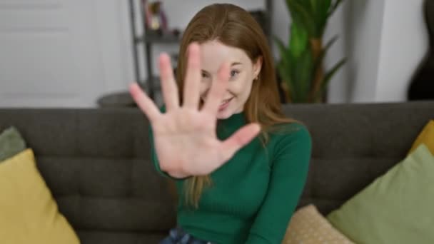 快乐的金发女青年自信地指着五个手指 穿着毛衣 在家庭欢乐的氛围中 快乐地分享着 的概念 — 图库视频影像