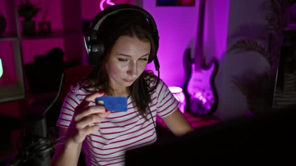 Zaostřená Žena Nošení Sluchátek Drží Kreditní Kartu Neonové Herně Noci — Stock video