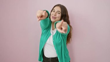 Heyecanlı genç İspanyol kadın sana büyük bir zevkle işaret ederken, aynı zamanda güzel, pozitif bir gülümsemeyle izole edilmiş pembe bir arkaplanı işaret ediyor.!