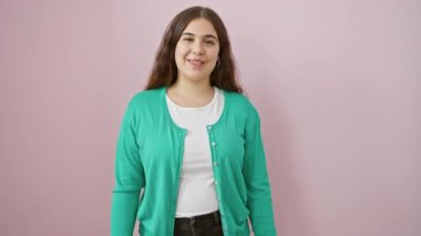 Kendine güvenen, ışıl ışıl, güzel İspanyol bir kadın gururlu, neşeli, pırıl pırıl pembe arka planda izole edilmiş mükemmel, serin bir gülümseme..