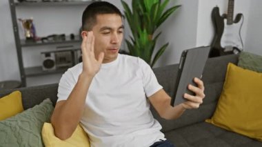 İspanyol bir adam evinde bir kanepede rahatça oturur, dijital tabletle meşgul olur..