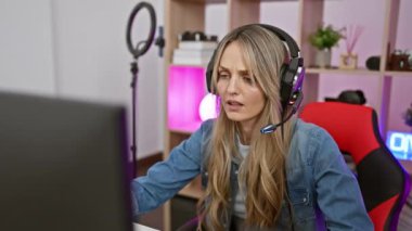 A young caucasian woman experiencing frustration while gaming in a modern home office setup at night