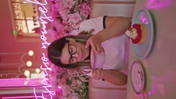 Junge Frau Genießt Dessert Einem Rosa Café Mit Neonlicht Und — Stockvideo