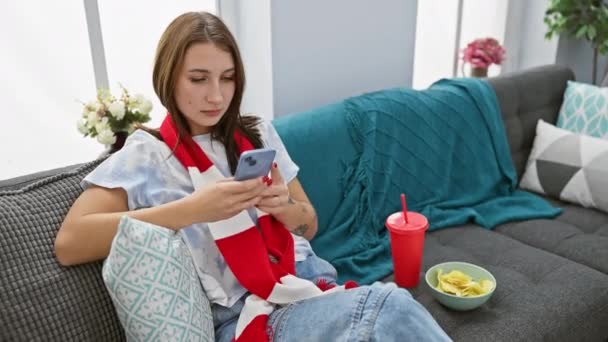 Tânără Relaxează Canapea Folosind Smartphone Înconjurată Gustări Într Cadru Confortabil — Videoclip de stoc