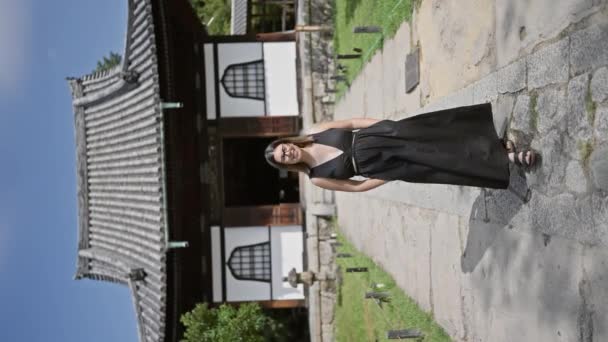 メガネをかけた美しいヒスパニック女性がカメラに向かって歩き 京都高台寺で笑顔を浮かべ 伝統的な日本の庭園の中でカジュアルな自信と楽しさの喜びの肖像画 — ストック動画