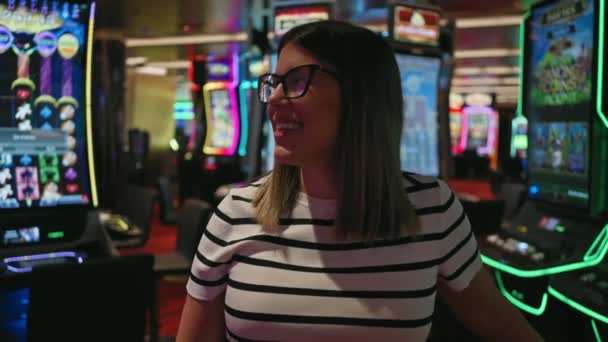 Una Mujer Sonriente Disfrutando Tiempo Casino Vibrante Rodeado Máquinas Tragamonedas — Vídeos de Stock