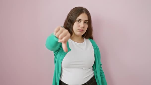 Привлекательная Молодая Испаноязычная Женщина Табличкой Опущенный Палец Стоящая Изолированном Розовом — стоковое видео