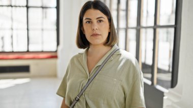 Yeni evinde ciddi bir ifadeyle duran güzel İspanyol bir kadın.