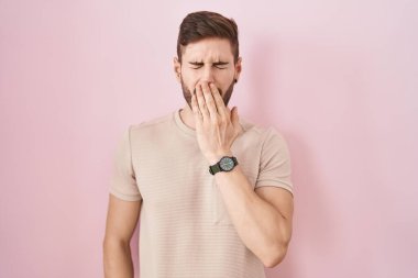 Pembe arka planda duran İspanyol sakallı adam ağzıyla ağzını kapatmaktan sıkılmış. Huzursuz ve uykulu.. 