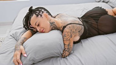 Göz kamaştırıcı, genç İspanyol bir kadın rahatlatıcı bir sabah geçiriyor, rahat bir şekilde yastığına sarılıyor, yatak odasının içindeki sıcak yatağında uzanıyor, mutluluk ve kendine güven saçıyor..