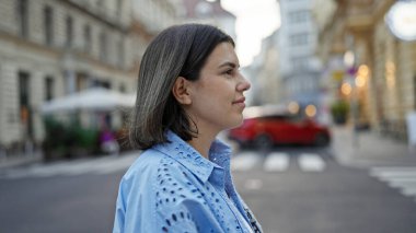 Güzel İspanyol bir kadın Viyana sokaklarında yaya geçidinden geçiyor.