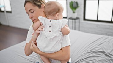 Kendine güvenen anne, eğlenceli anların tadını çıkarıyor, yatakta oturuyor, güzel kızına rahat yatak odasında uykusunun mutluluğunu diliyor. Sıradan, mutlu aile yaşam tarzının mükemmel ifadesi..