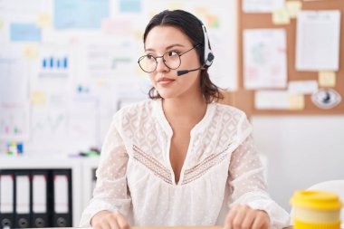 Ofiste çalışan İspanyol asıllı genç bir kadın. Kulaklık ve gözlük takıyor. Taraf arıyor.. 