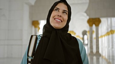 Abu Dabi Camii 'nde tesettürlü gülümseyen kadın İslami mimari ve turizm sergiliyor..