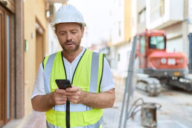 Sokaklarda akıllı telefon kullanan orta yaşlı bir mimar.