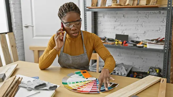 非洲裔美国妇女在研讨会上通过电话交谈 同时从一块石板上选择颜色 — 图库照片