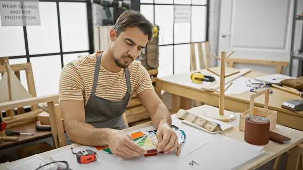 Focused Hispanic Man Examines Color Swatches Well Lit Carpentry Workshop — Stock Photo, Image
