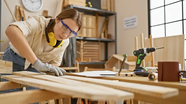Młoda Brunetka Pracuje Drewnem Dobrze Wyposażonym Warsztacie Stolarskim Emanując Umiejętnościami — Zdjęcie stockowe