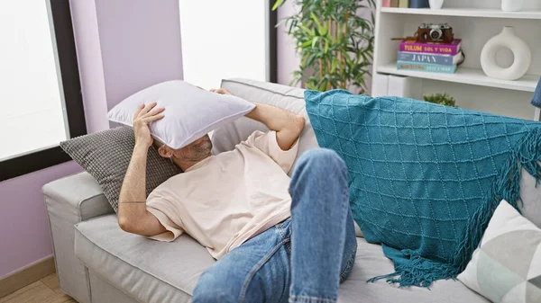Young Hispanic Man Lying Sofa Covering Face Cushion Home — Stock Photo, Image
