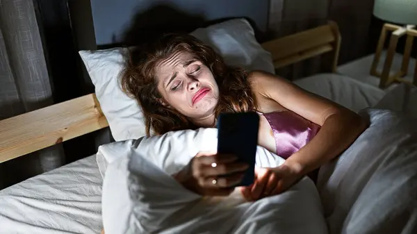 Young Caucasian Woman Looks Smartphone Sadness Dimly Lit Bedroom — Stock Photo, Image