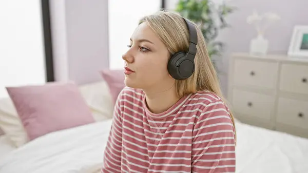 Μια Σκεπτική Νεαρή Γυναίκα Που Φοράει Ακουστικά Κάθεται Ένα Υπνοδωμάτιο — Φωτογραφία Αρχείου