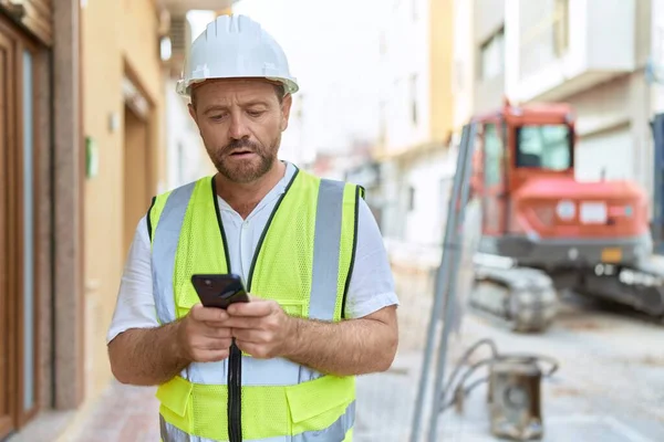 Sokaklarda akıllı telefon kullanan orta yaşlı bir mimar.