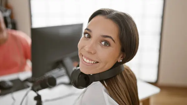 Smiling confident man and woman radio interviewers engaged in live broadcast in a professional radio studio, staged for speaking, listening, and delivering news on air