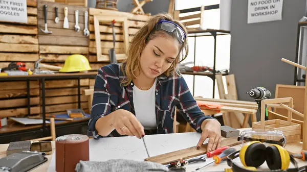 Attractive Young Hispanic Woman Carpenter Dressed Safety Glasses Skillfully Jots — Stock Photo, Image