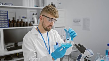 Kafkasyalı adam laboratuarda kimyasalları inceliyor, araştırma yapıyor.