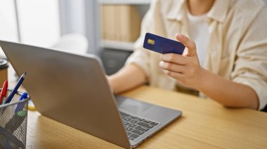 Güçlü İspanyol iş kadını, lüks ofisinde kredi kartı ve dizüstü bilgisayarı ustalıkla kullanıyor..